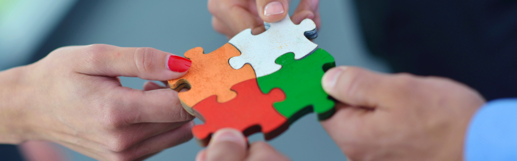 White, green, orange, and red puzzle pieces fitting together.