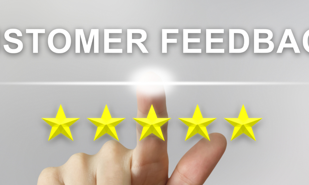 A person's finger in front of a white background with their finger touching above a line of five starts and text above their finger that reads "Customer Feedback."