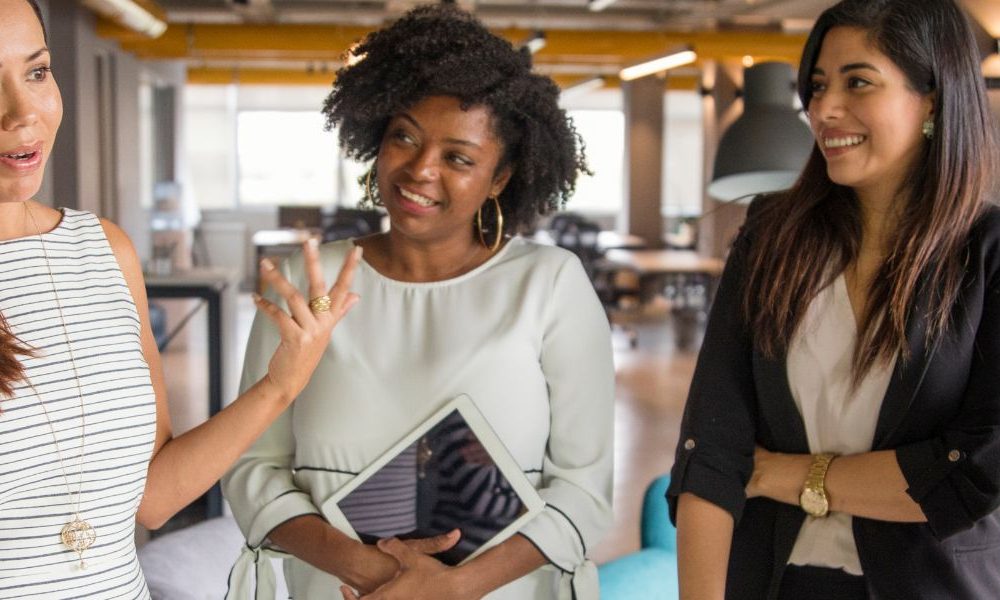 A group of employees talking to one another in an office.