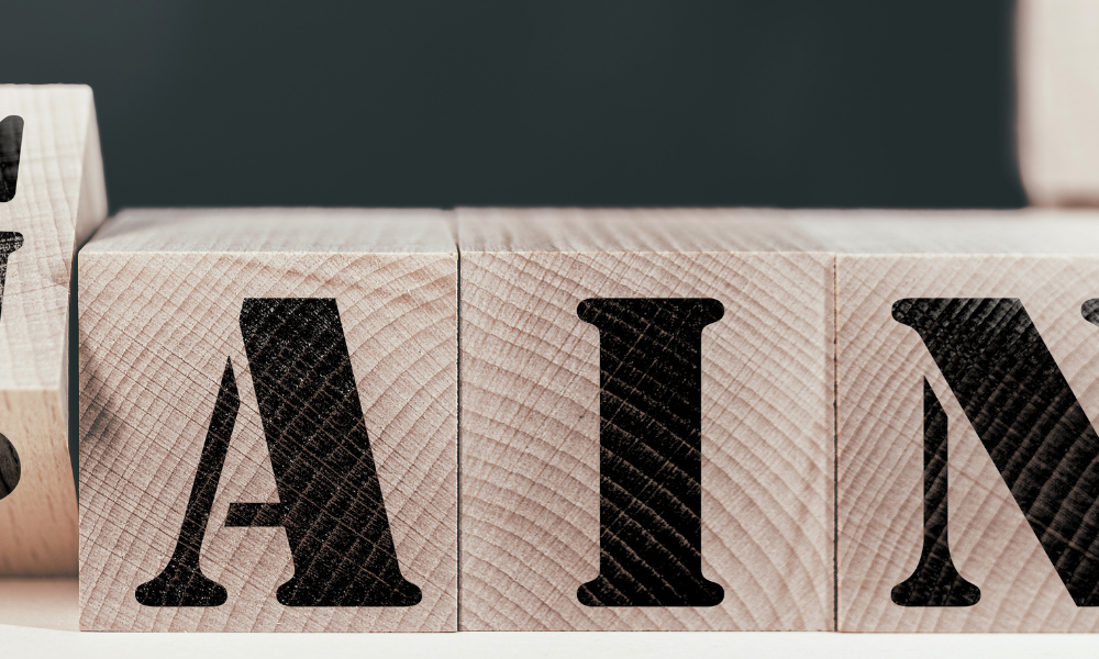 Wood blocks on a table with black font that spells pain or gain.