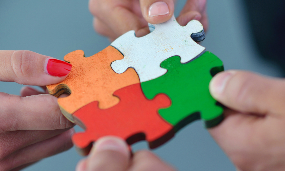 White, green, orange, and red puzzle pieces fitting together.