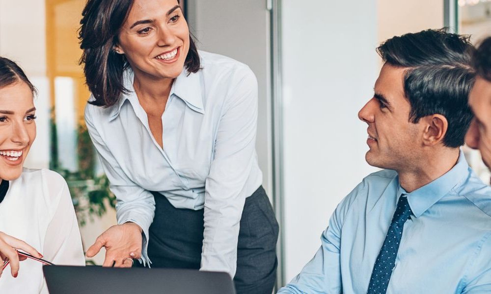 People working together in an office at a conference table.