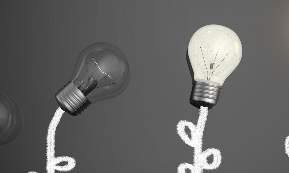 Four lightbulbs against a black chalkboard.