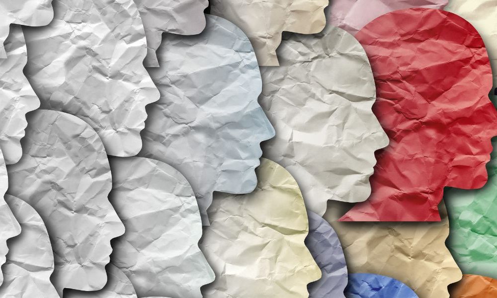 White paper cut outs of human heads that slowly transition to colours.