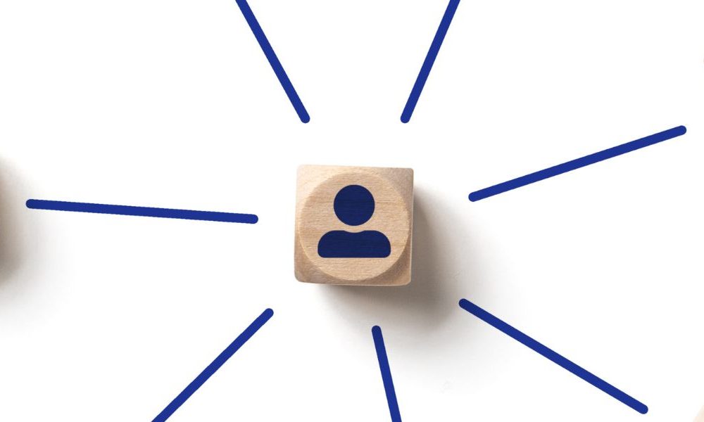 Brown wooden blocks with graphics of people painted on them connected with lines against a white background.